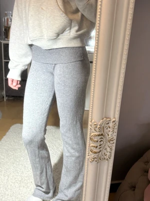 Grå mjukisbyxor från Gina Tricot - Mysiga grå mjukisbyxor från Gina Tricot med bred ribbad midja och raka ben. Byxorna är tillverkade i mjukt material och har en enkel, stilren look som passar perfekt till chill dagar hemma eller när du vill vara bekväm men ändå se snygg ut. Dom har använts 1/2 gånger för de är inte min stil.