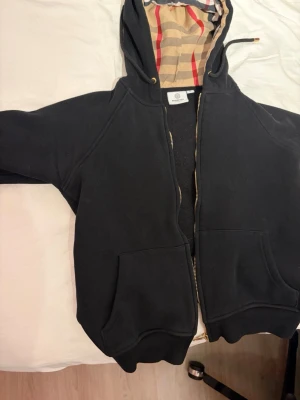 Burberry hoodie svart - En svart burberry hoodie med dragkedja storlek M men passar mer som s eller xs