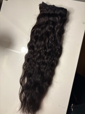 Mörkbrunt vågigt löshår - Säljer ett paket mörkbrunt löshår med naturligt vågig textur. Perfekt för dig som vill ha extra volym och längd. Håret är mjukt och glansigt, och kan stylas efter önskemål. Passar till clips, tejp eller insytt.