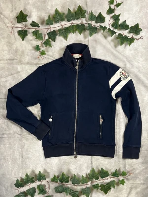 Moncler Maglia Cardigan Zip – Navy – Strl M - "|Färg: Navy/mörkblå, vita detaljer | Modell: Maglia Cardigan Zip, lätt jacka | Storlek: M, normal passform | Skick: Grade A, 9/10 | Hör av dig ifall du har funderingar!"