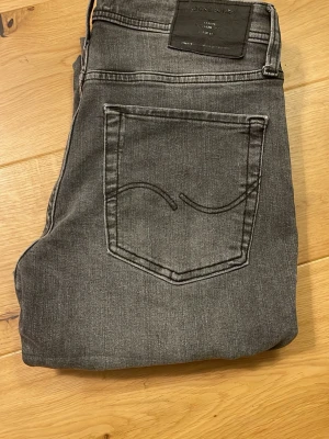Grå jack & Jones jeans - Schyssta gråa jeans från Jack & Jones med klassisk femficksdesign. Jeansen har slim fit passform och är Perfekta till en avslappnad stil. W28 L30