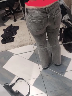 Gråa bootcut jeans med låg midja - Säljer ett par gråa jeans med låg midja och bootcut.