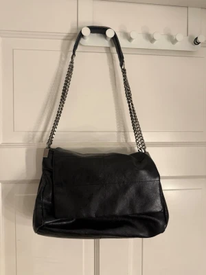 Svart väska zara - Snygg svart väska från zara med 3 fack, den har fått lite slitage på handtaget men inget man tänker på