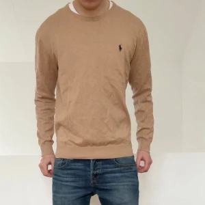 Ralph Lauren beige tröja - Säljer en sjukt fet tröja från Ralph Lauren i färgen beige. Tröjan är i bra skick då den har varit väl omhändertagen och är i L men sitter mer som M. Hör gärna av er vid frågor elr funderingar!!