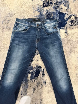 Blå Replay Anbass jeans  - Säljer ett par Replay Anbass jeans i blå tvätt. Riktigt snygga och passar med alla outfits! Storlek 33/32 men sitter mindre. Han på bild är 185cm, 74kg. 