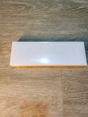 Apple Watch - Oöppnad Apple Watch i originalförpackning. Inkluderar klocka, armband och USB-C laddkabel. Förpackningen är i nyskick utan synliga skador eller slitage. Perfekt för dig som vill ha en smartklocka med stilren design och avancerade funktioner.