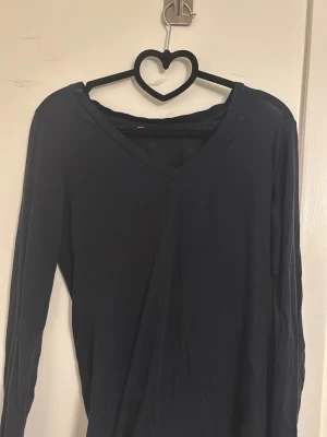 Svart långärmad topp från Uniqlo - En svart långärmad topp från Uniqlo i storlek S. Toppen har en snygg v-ringning och är gjord i ett tunt matrial. Skriv för fler frågor, prisförslag eller bilder  !