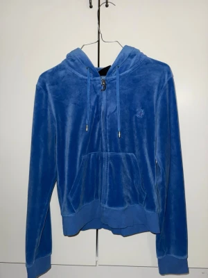 Juicy couture - Säljer nu min blåa juicy couture zip hoodie i storlek M då den inte kommer till användning längre, har bara använt den ett par fåtal gånger och hoppas att den kommer till bättre användning hos någon annan.