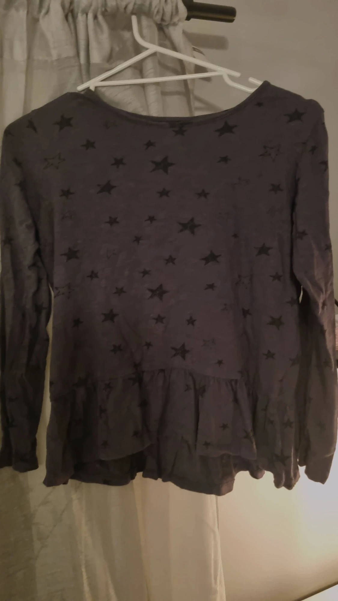 Svart blus med stjärnmönster och volang