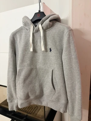 Ralph lauren hoodie - Säljer min gråa hoodie frånRalph lauren med vit snörning och mörkblå  broderad logga. Använts väldigt få gånger och skicket är som nytt. Tröjan kan även baras som XS Extremt prisvärt för skicket!