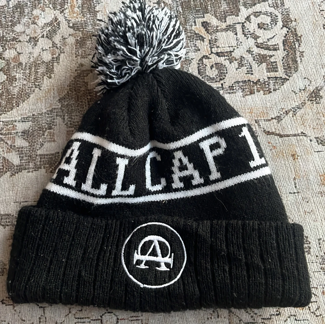 Svart och vit mössa med tofs från Allcap1