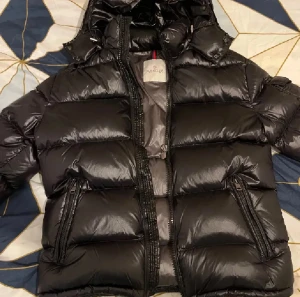Svart Moncler pufferjacka Maya - Säljer en svart pufferjacka från Moncler, Storlek 3, motsvarar S/M. Sparade tyvärr aldrig kvittot därför pris lägre, inga defekter, alla taggar/scan finns, tveka absolut inte av frågor. Behov av snabb affär, kan gå ner i pris vid seriöst köp. 