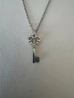 Silverhalsband mindre nyckel - Perfekta julklappen 🌲  Säljer smycken som skapats som hobby av mig och dottern.   Halskedjor är 50cm.  Bilder på berlock kan vara missvisande så är det viktigt så fråga gärna om mått 🌹  Smycken är inte av äkta guld/silver .   Inga bud godtas då priserna är så billiga❤️