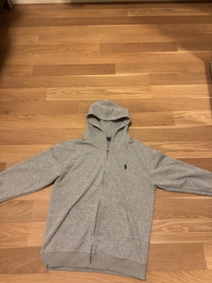 Grå polo zip up hoodie - En grå ralph lauren zip up hoodie som jag inte använder för att har bytt stil annars är den i jätte bra skick och ganska bekväm