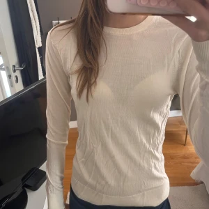 Vit stickad tröja från Uniqlo - Säljer en tunn, vit stickad tröja från Uniqlo i storlek XS. Tröjan har rund halsringning och långa ärmar, perfekt för lager-på-lager. Enkel och stilren design som funkar till det mesta. Materialet är mjukt och lätt, vilket gör den skön att bära.