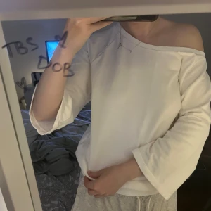 Vit offshoulder tröja i bomull - Säljer en vit offshoulder tröja i mjuk bomull. Tröjan har trekvartsärmar och en avslappnad passform som ger en chill vibe. Perfekt för dig som gillar en enkel men snygg stil.