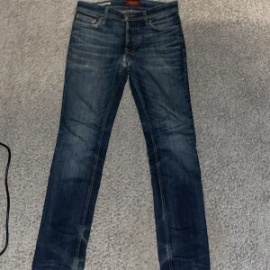 Jack & Jones jeans - Säljer nu mina Jack and Jones jeans, passformen är slim och är väldigt bra, anledningen till att jag säljer jeansen är för att de inte kommer till användig. Skicket är väldigt bra det är bara att jagchqr gått till skräddaren med jeansen, det var hål innan men det är fixat nu, ni ser de på tredje bilden. Just denna modell av jeansen säljs ej längre. Skriv för fler frågor eller bilder. Önskar er allt gott//Kevin