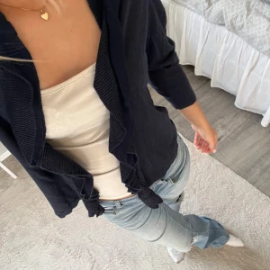 Marinblå kofta med volanger - Jag säljer en mörkblå finstickad kofta med volanger i storlek M, men skulle säga att den är liten i storleken. Hör av dig vid frågor!💗