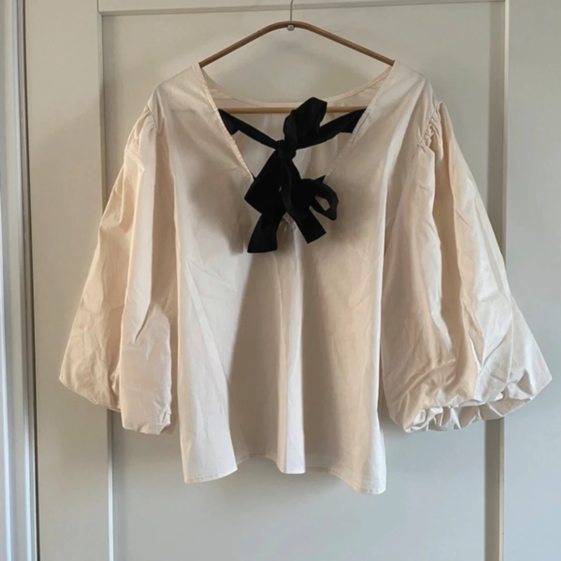 Beige blus med puffärmar och svart rosett