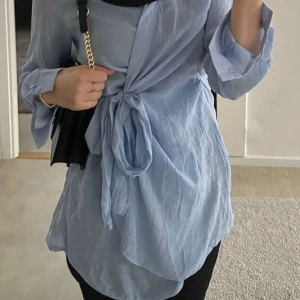 H&M Skjortklänning med knytband - Jättefin ljusblå skjortklänning i storlek S/M. Lite luddig på ett ställe som visas i bild ovan!