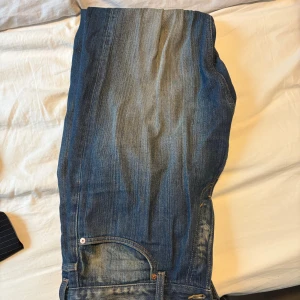 Blå raka jeans från Weekday W31 L32 - Snygga blå jeans från Weekday i rak modell. Jeansen har klassisk femficksdesign, tydliga slitningar och kontrastsömmar. Tillverkade i bomull och passar perfekt för en avslappnad stil.