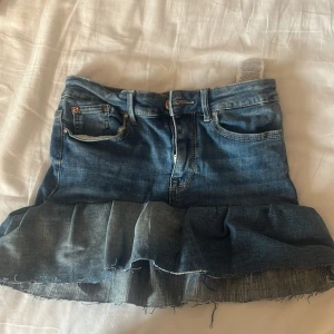 Jeanskjol med volangkant - Snygg blå jeanskjol med volang längst ner. Jag har gjort kjolen själv och därför ingen exakt storlek men de passar mig som är S