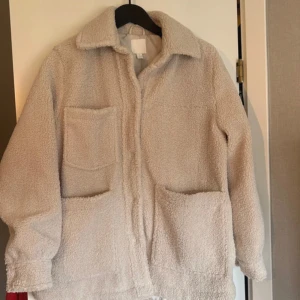 Superfin teddyjacka - Mysig beige teddyjacka med tre stora utanpåfickor och klassisk krage. Ifrån H&M, overdized, storlek S men passar även mig som har storlek M🌸