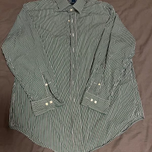 Grön randig skjorta Polo Ralph Lauren - Snygg grön och vit randig skjorta från Polo Ralph Lauren, modell Regent Classic Fit. Skjortan har klassisk krage, långa ärmar med manschett och vita knappar framtill. Perfekt för dig som gillar stilrena och tidlösa plagg med en fräsch vibe.