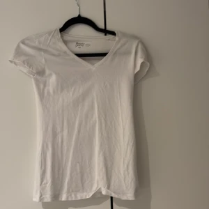 Vit v-ringad t-shirt Basic You XS - Vit t-shirt från Basic You i ekologisk bomull. Modellen är v-ringad och har korta ärmar. Enkel och stilren design som passar till det mesta. Perfekt basplagg i garderoben.