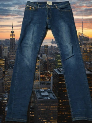 jeans från Morris - Snygga mörkblå jeans från Morris med klassisk femficksdesign och kontrastsömmar. Jeansen är tillverkade i 98% bomull och 2% elastan för skön stretch. Passar dig som gillar en lite bredare benslut och stilren look.