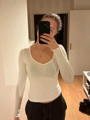 White Long Sleeve Top with U-Neck – Nelly – Size XS - Thin white long sleeve top from Nelly in size XS. Features a small U-shaped neckline with a subtle crinkled/ruffled trim that adds a feminine detail☺️  Bought about a year ago and gently used, but it looks like new. No stains, damage, or visible signs of wear. Soft, lightweight fabric – perfect for everyday wear or layering☺️