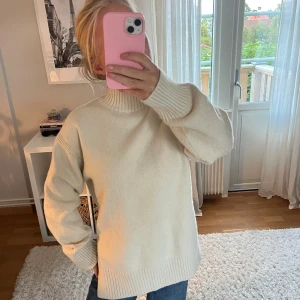 Vit polotröja i stickat material - Säljer en krämvit polotröja i stickat material med hög krage och breda ribbade muddar. Tröjan har en loose passform och är perfekt för kyliga dagar. Enkel och stilren design som är lätt att matcha med jeans eller kjol🙌🏼🙌🏼🩷🩷