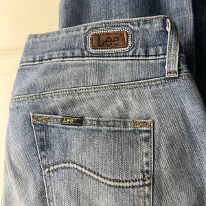 Ljusblå Lee jeans - Säljer ett par klassiska ljusblå jeans från Lee. Jeansen har fem fickor, Lee-logga på bakfickan och knappgylf. Perfekta till vardags för en avslappnad look. 