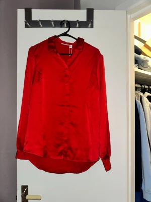 Röd skjorta/blus - Märket är vila aldrig använd, tröjan är lite längre baktill än framtill, knappar framtill. 
