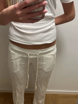 Vita linnebyxor med snörning XS - Säljer ett par vita linnebyxor i storlek XS med bred resår i midjan och snörning framtill. Byxorna har stora fickor både fram och bak, och är tillverkade i ett tunt och luftigt linnematerial. Perfekta för en chill och avslappnad stil.