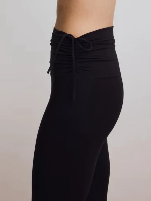 Svarta bootcut leggings med snörning - Säljer ett par svarta träningsbyxor med bootcut-modell. Byxorna har snygg snörning i sidorna vid midjan och är tillverkade i funktionsmaterial med softmove som sitter skönt på kroppen. 