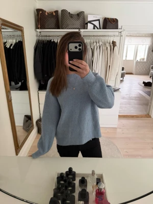 Ljusblå stickad tröja med ballongärm - Supermysig ljusblå stickad tröja med ballongärmar och rund hals. Tröjan har en relaxed fit och är perfekt att slänga på sig när det är lite kyligare ute. Enkel att matcha med både jeans och kjol.