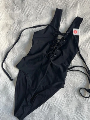 Ny Baddräkt 🖤 - Snygg baddräkt med snörning från Bik Bok i storlek XS. Ny med prislappar kvar! Nypris 349kr 🖤