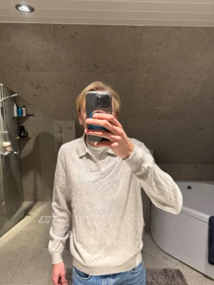 Ljusgrå 100% kashmirtröja - Säljer en stilren ljusgrå långärmad tröja från Mango man i 100% kashmir. Tröjan har klassisk krage och relaxed fit, perfekt till jeans eller chinos. Supermjuk och skön mot huden, passar dig som gillar en clean och enkel look. Jag på bilden är 183 cm