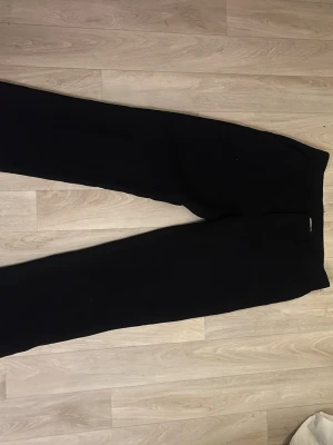 Svarta kostymbyxor från Nelly - Uppsprättade ner till men ingen man ser när de sitter på. Säljer ett par svarta kostymbyxor från Nelly i storlek S. Byxorna har raka ben och klassisk passform med bälteshällor i midjan. Materialet känns mjukt och följsamt, perfekta till en clean och stilren look.