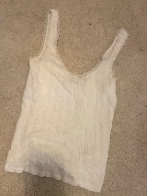 Vit topp - Ett sött linne med mönster och spets. Köpt 2022 men i super bra skick