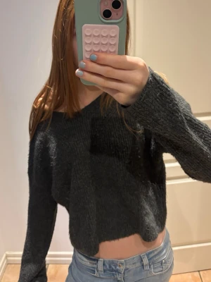 Mörkgrå stickad tröja - ‼️PRIS KAN DISKUTERAS‼️STORLEK 164, passa mig som använder xs/s. Säljer en mörkgrå croppad stickad tröja med lång ärm och avslappnad passform. Tröjan har en lätt oversized känsla och sitter snyggt offshoulder. Perfekt till jeans för en chill look. Tröjan är lite nopprig. 