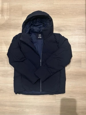 Mörkblå Seamless Down Parka Uniqlo - Säljer en mörkblå pufferjacka från Uniqlo med huva och dragkedja. Pris kan diskuteras vid snabb affär!🤗nypris 1499kr