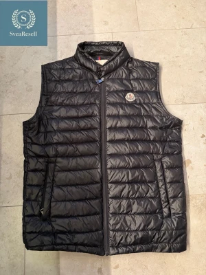 Svart Moncler Väst - Säljer en svart snygg Moncler väst. Perfekt till våren🌄                                                           Märke: MONCLER                                                          Färg: Svart.                                                                                 Skick: 7/10.                                                                            Kom privat om du undrar nåt 🤩   
