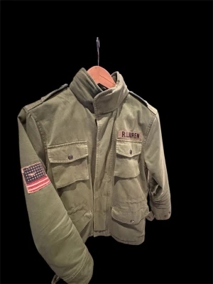 Fieldjacka från Ralph Lauren - En skön militär inspirerad fieldjacka. Skön olivgrön färg som passar perfekt nu inför våren. Jackan har inga defekter, självklart tecken på användning med inte mycket. PRISET GÅR ATT DISKUTERA!!.