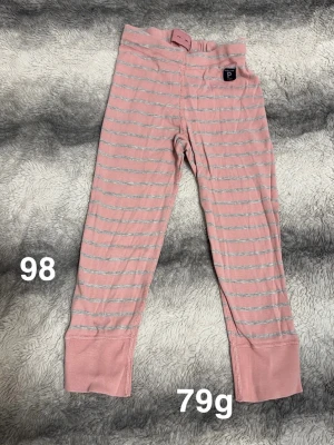 Rosa randiga leggings Polarn O. Pyret - Säljer ett par mjuka rosa leggings från Polarn O. Pyret med tunna grå ränder. Byxorna har breda muddar vid bensluten och elastisk midja för skön passform. Perfekta för lek och vardag.🌸 Fint använt skick. Storlek 98