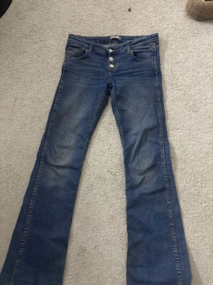 Blå bootcut jeans Gina Tricot 152 - Säljer ett par blå bootcut jeans från Gina Tricot i storlek 152. De är lite smutsiga i ändan av ändan av byxan men det går enkelt att tvätta bort.