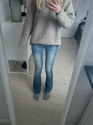  bootcut jeans med slitningar - Säljer ett par blå bootcut jeans med slitna detaljer och en vinted Y2K-stil💘 midwaist men brukar själv vika ner dem🌸 omsydda till bootcut men ser verkligen inte omsydda ut!🤩