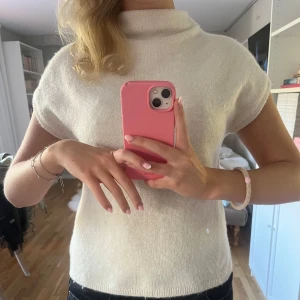 Beige stickad tröja med kort ärm Lindex - Superfin beige stickad tröja från Lindex med korta ärmar och hög krage. Enkel och stilren modell som är perfekt att styla med jeans eller kjol. Mjuk och skön, passar perfekt för lager-på-lager under höst och vår. Använd fåtal gånger 💓💓