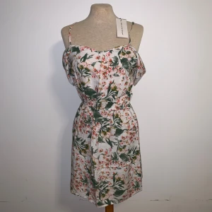 Helt ny blommig kortklänning med axelband - Supersöt kortklänning från Jacqueline de yong med offshoulder-detalj. Prislapp och allt sitter kvar. Nypris: 190kr